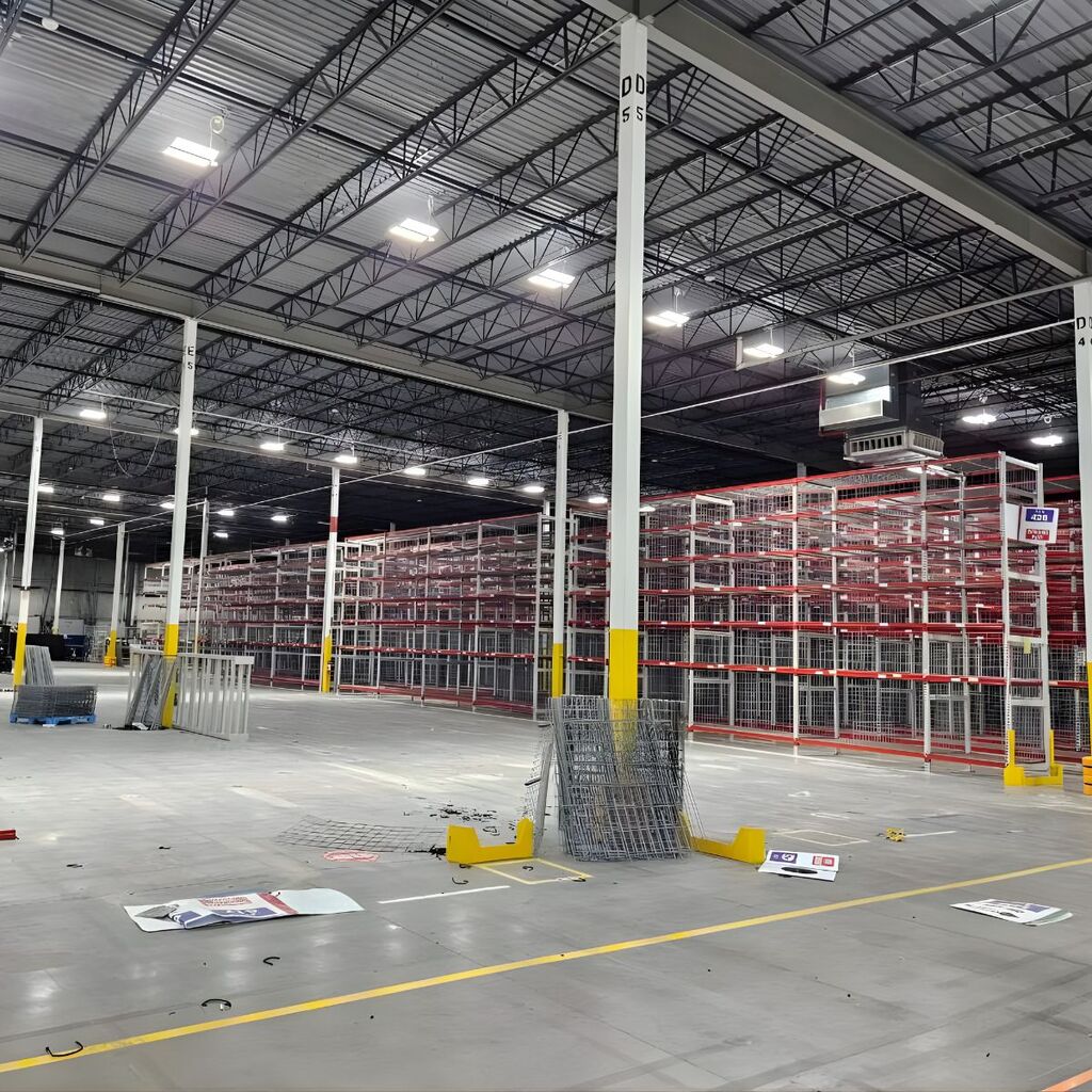 Completed industrial storage system with integrated safety column guards and structural concrete anchoring.